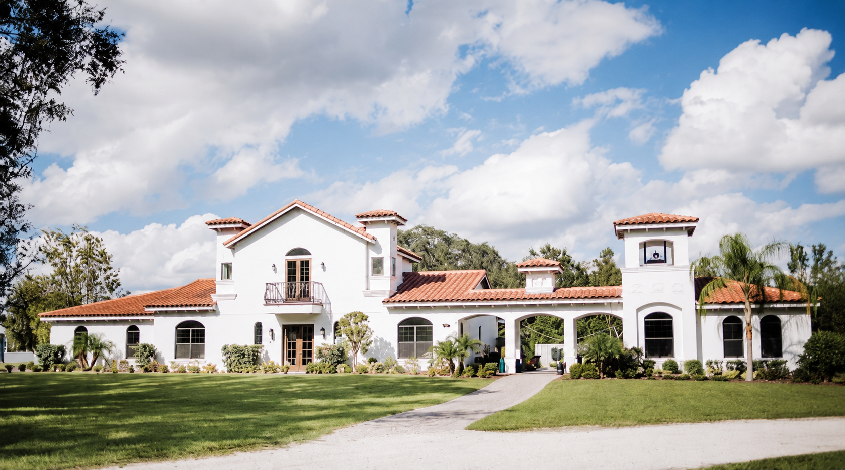 The white Tuscan-style villa and front lawn at Paradise Springs